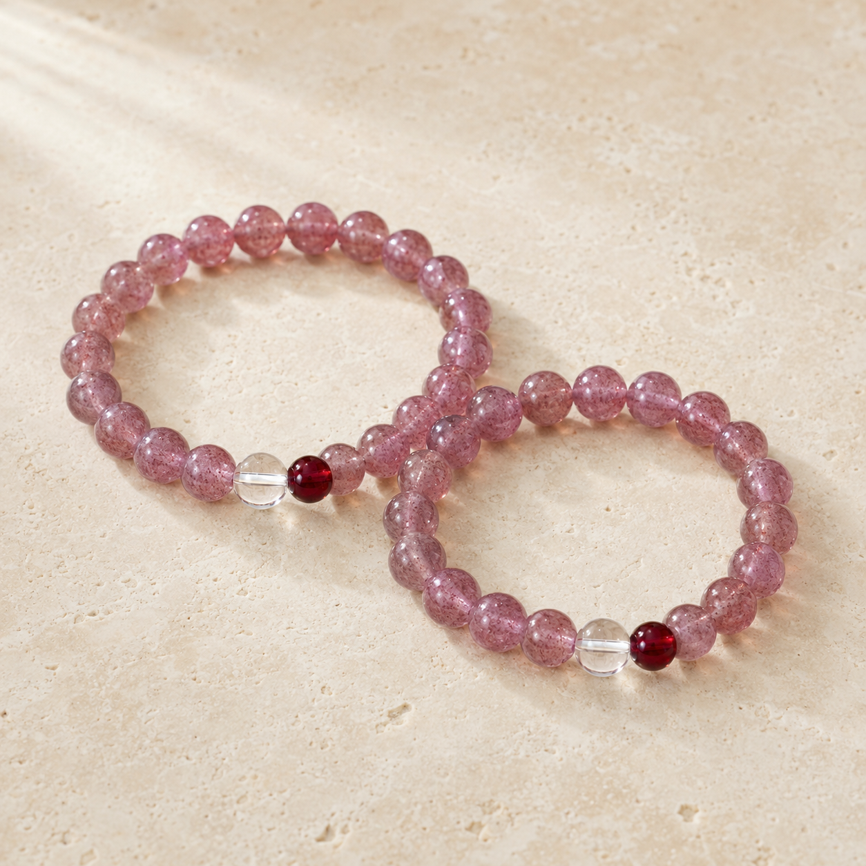 Two Strawberry Quartz, Clear Quartz & Garnet Bracelets held in hand