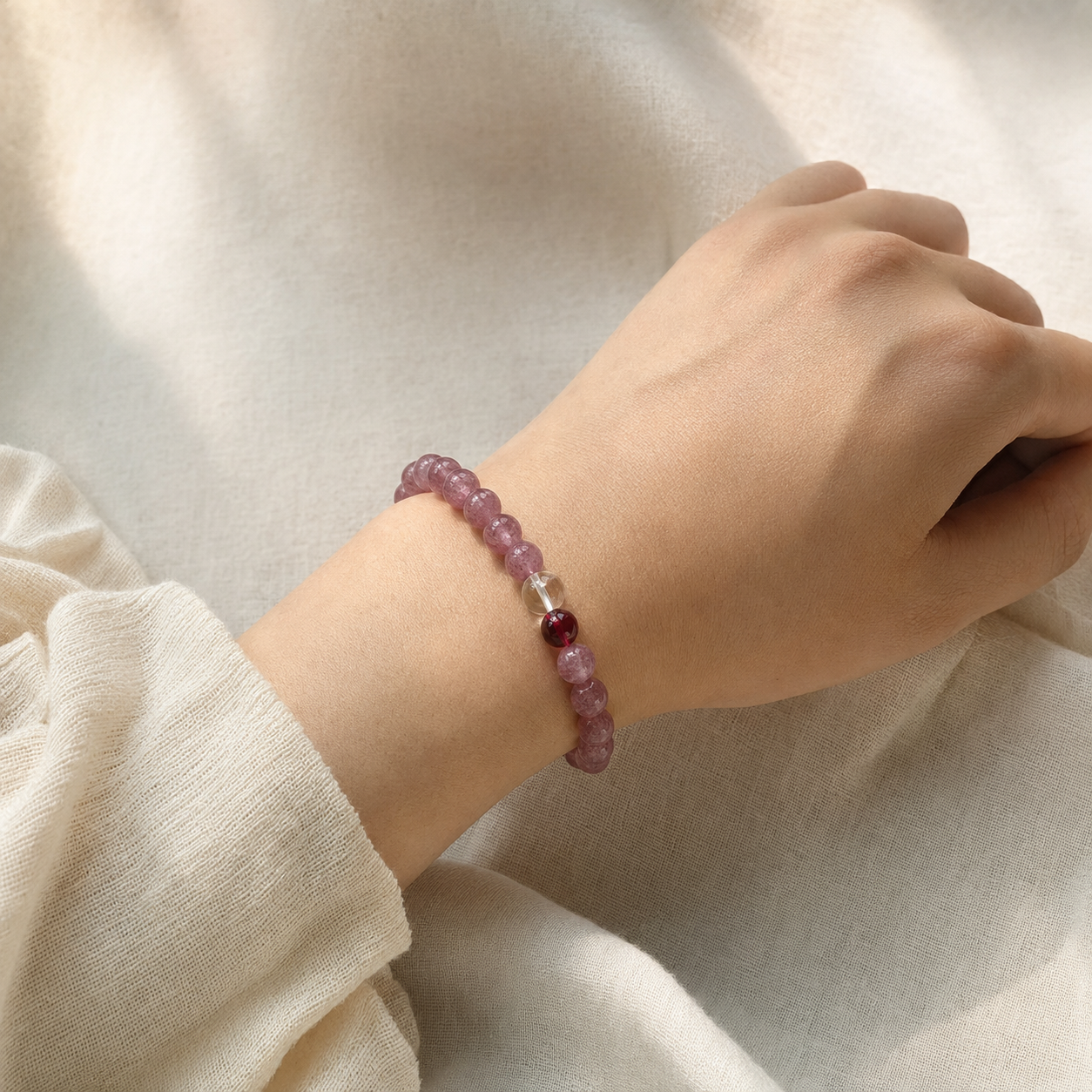 Two Strawberry Quartz, Clear Quartz & Garnet Bracelets on flat surface