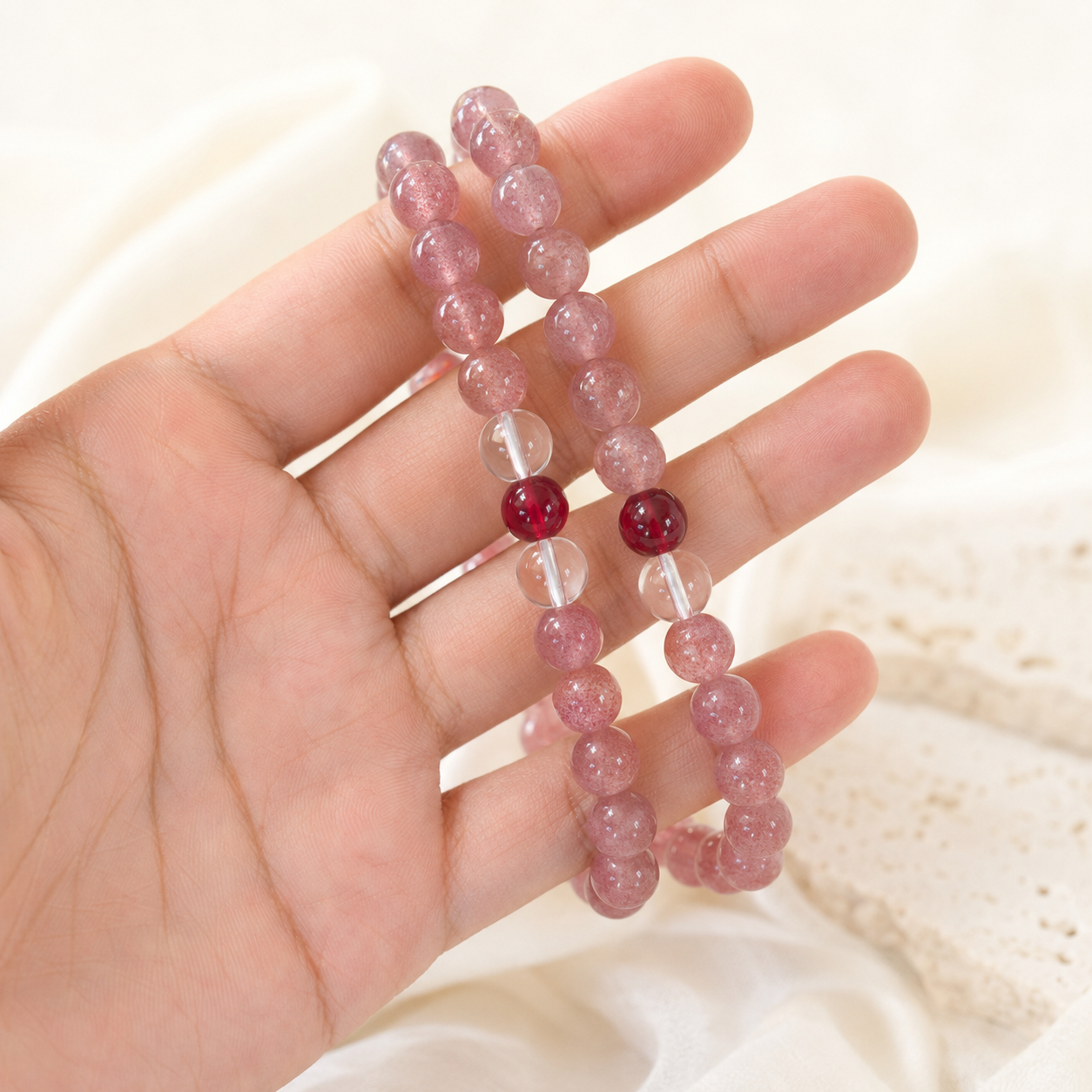 Single Strawberry Quartz, Clear Quartz & Garnet Bracelet on flat surface